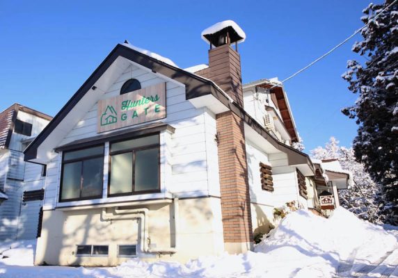 ハンターズゲートは飯山市の戸狩に位置し、山の景色を望むゲレンデ直結の宿泊施設で、共用ラウンジを提供しています。共用ラウンジには卓球台、ピアノ、ギター、ドラムなどがあります。